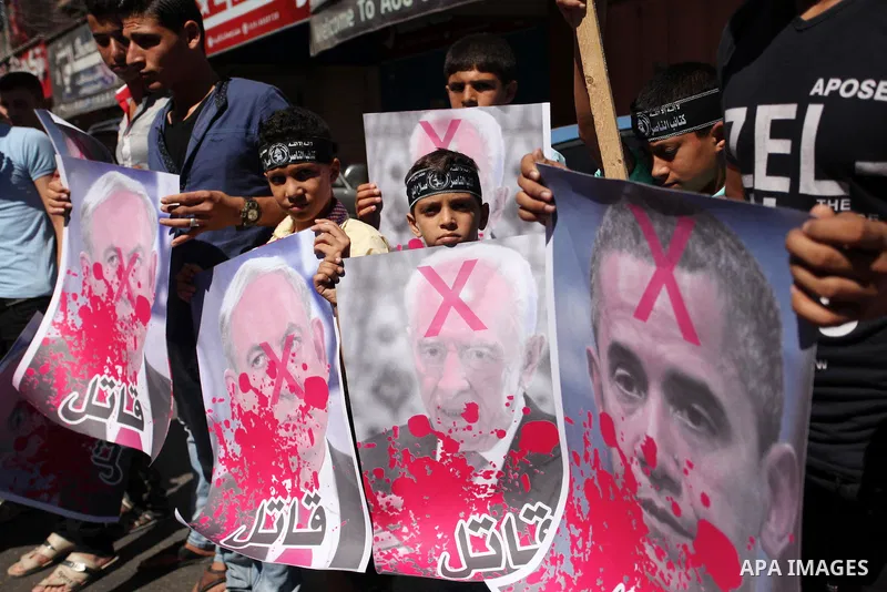 Palestinians hold crossed posters of former Israeli President Shimon Peres, U.S. President Barack Obama and Israeli Prime Minister Benjamin Netanyahu before burning them during a rally following Friday prayers in Gaza Ci...