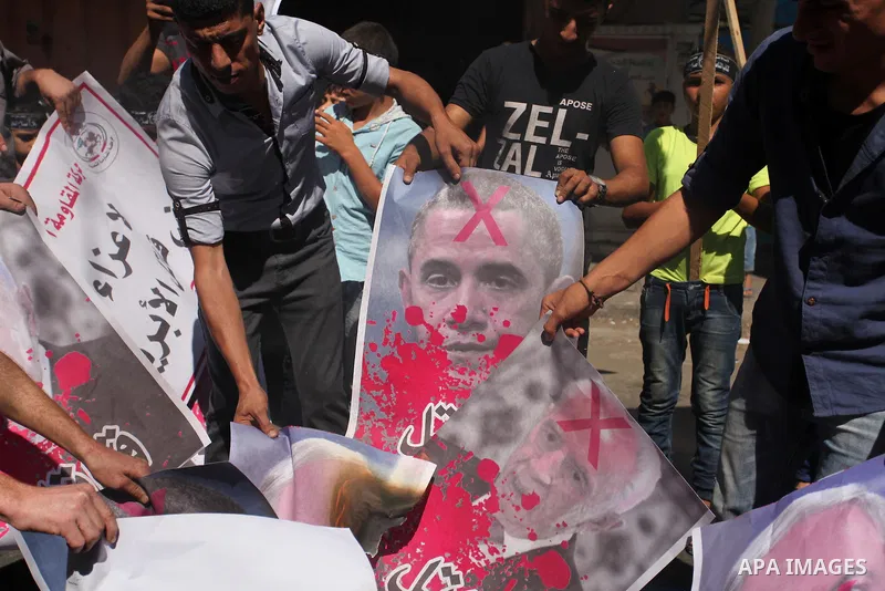 Palestinians burn crossed posters of former Israeli President Shimon Peres, U.S. President Barack Obama and Israeli Prime Minister Benjamin Netanyahu during a rally following Friday prayers in Gaza City September 30, 201...
