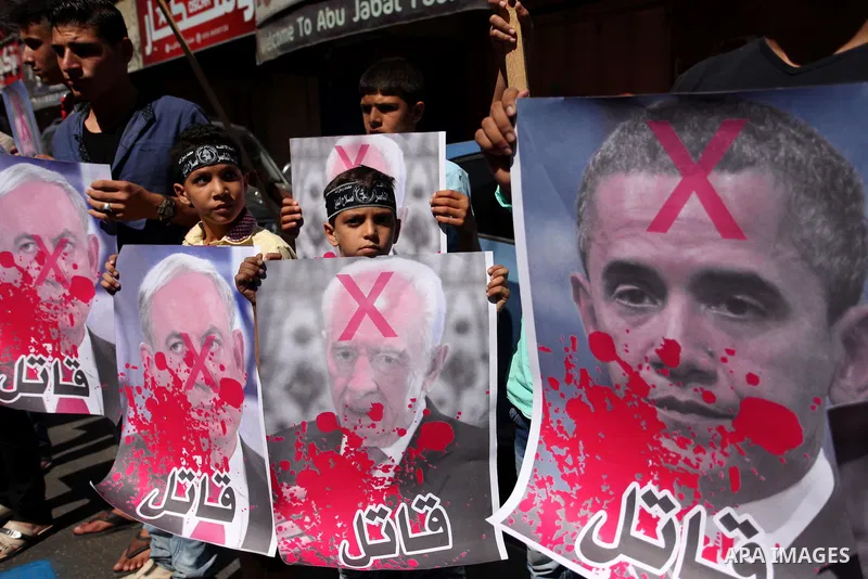Palestinians hold crossed posters of former Israeli President Shimon Peres, U.S. President Barack Obama and Israeli Prime Minister Benjamin Netanyahu before burning them during a rally following Friday prayers in Gaza Ci...