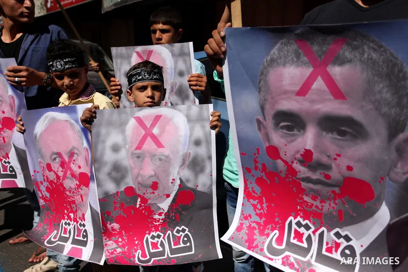 Palestinians hold crossed posters of former Israeli President Shimon Peres, U.S. President Barack Obama and Israeli Prime Minister Benjamin Netanyahu before burning them during a rally following Friday prayers in Gaza Ci...