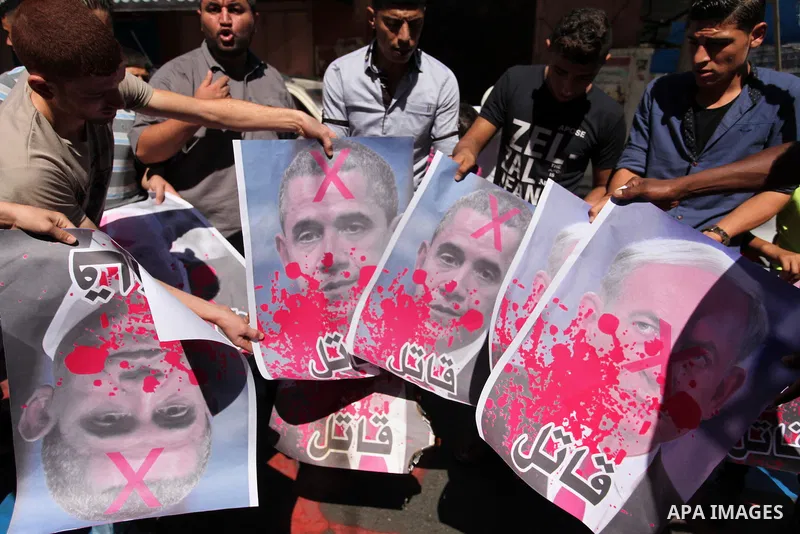 Palestinians burn crossed posters of former Israeli President Shimon Peres, U.S. President Barack Obama and Israeli Prime Minister Benjamin Netanyahu during a rally following Friday prayers in Gaza City September 30, 201...