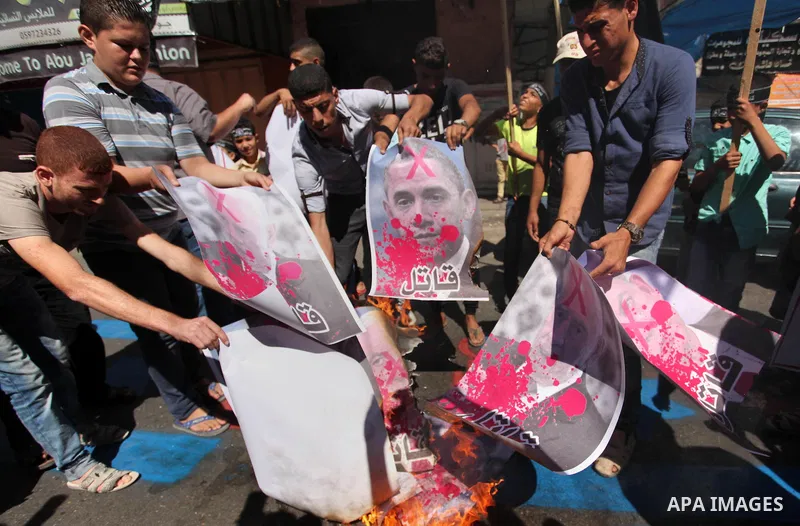 Palestinians burn crossed posters of former Israeli President Shimon Peres, U.S. President Barack Obama and Israeli Prime Minister Benjamin Netanyahu during a rally following Friday prayers in Gaza City September 30, 201...