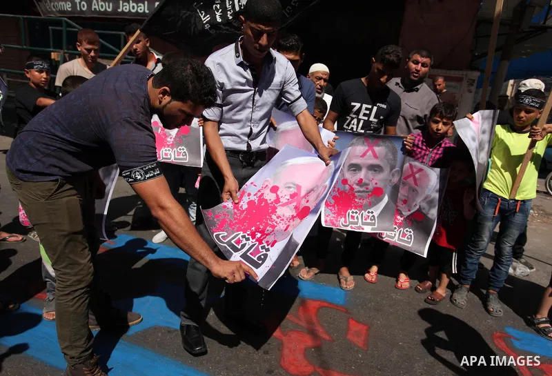 Palestinians burn crossed posters of former Israeli President Shimon Peres, U.S. President Barack Obama and Israeli Prime Minister Benjamin Netanyahu during a rally following Friday prayers in Gaza City September 30, 201...