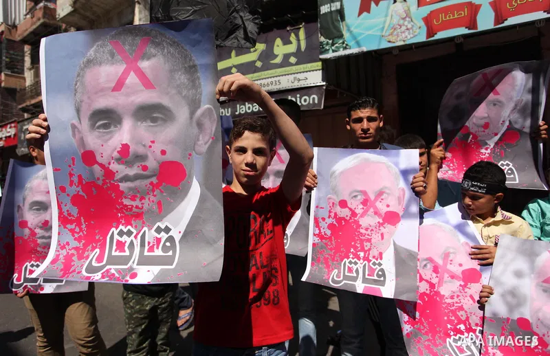 Palestinians hold crossed posters of former Israeli President Shimon Peres, U.S. President Barack Obama and Israeli Prime Minister Benjamin Netanyahu before burning them during a rally following Friday prayers in Gaza Ci...