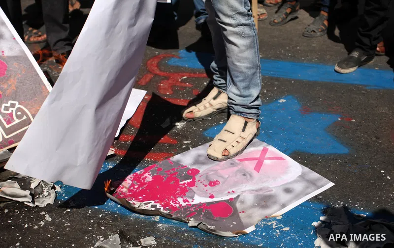 A Palestinian steps on a crossed poster of former Israeli President Shimon Peres, reading "Murderer", during a rally following Friday prayers in Gaza City September 30, 2016. Photo by Ashraf Amra