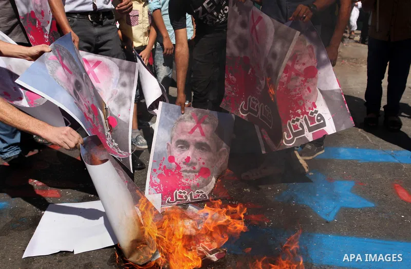 Palestinians burn crossed posters of former Israeli President Shimon Peres, U.S. President Barack Obama and Israeli Prime Minister Benjamin Netanyahu during a rally following Friday prayers in Gaza City September 30, 201...