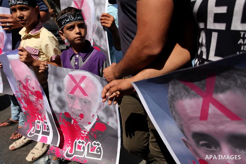 Palestinians hold crossed posters of former Israeli President Shimon Peres, U.S. President Barack Obama and Israeli Prime Minister Benjamin Netanyahu before burning them during a rally following Friday prayers in Gaza Ci...