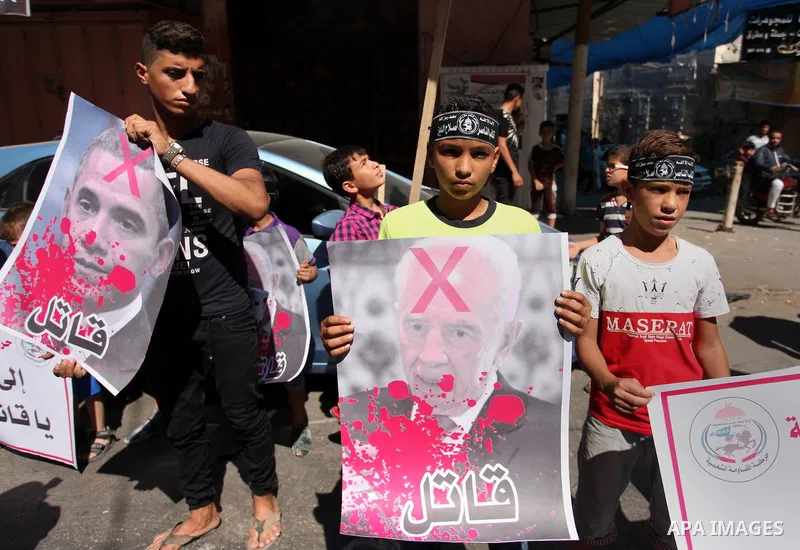 Palestinians hold crossed posters of former Israeli President Shimon Peres, U.S. President Barack Obama and Israeli Prime Minister Benjamin Netanyahu before burning them during a rally following Friday prayers in Gaza Ci...