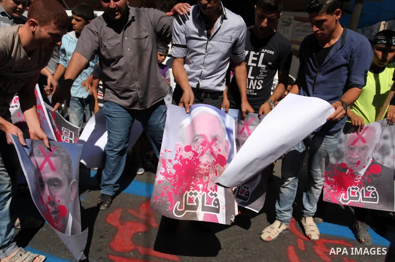 Palestinians burn crossed posters of former Israeli President Shimon Peres, U.S. President Barack Obama and Israeli Prime Minister Benjamin Netanyahu during a rally following Friday prayers in Gaza City September 30, 201...