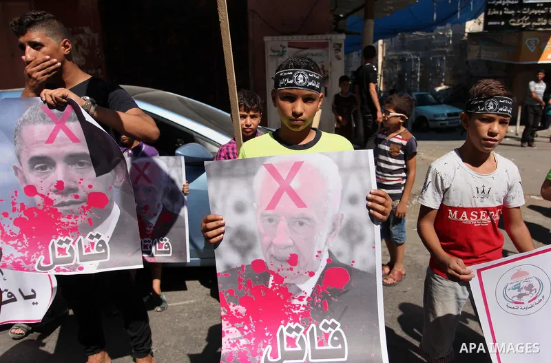 Palestinians hold crossed posters of former Israeli President Shimon Peres, U.S. President Barack Obama and Israeli Prime Minister Benjamin Netanyahu before burning them during a rally following Friday prayers in Gaza Ci...
