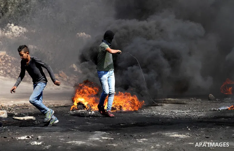 Palestinian protesters burn tires during clashes with Israeli security forces following a weekly demonstration against the expropriation of Palestinian land by Israel on Sep. 30, 2016, in the village of Kfar Qaddum, near...