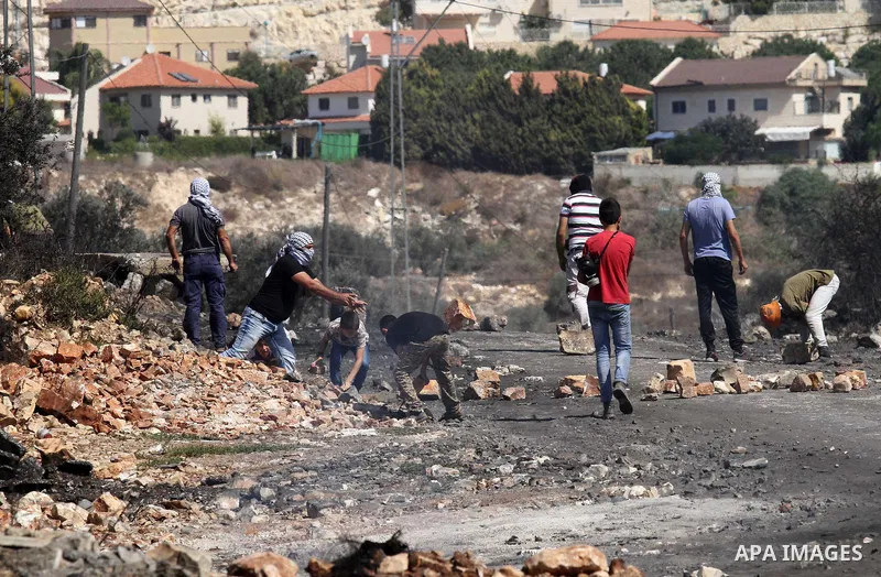 Palestinian protesters hurl stones toward Israeli security forces during clashes following a weekly demonstration against the expropriation of Palestinian land by Israel on Sep. 30, 2016, in the village of Kfar Qaddum, n...