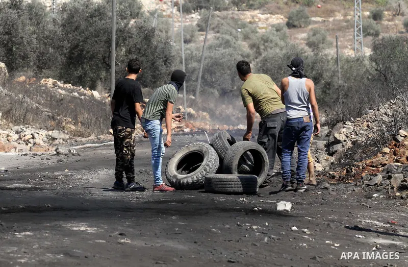 Palestinian protesters burn tires during clashes with Israeli security forces following a weekly demonstration against the expropriation of Palestinian land by Israel on Sep. 30, 2016, in the village of Kfar Qaddum, near...
