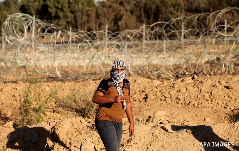 A Palestinian protester uses a slingshot to hurl stones toward Israeli security forces during clashes near the border between Israel and Central Gaza Strip east of Bureij on Sep. 30, 2016. Photo by Ashraf Amra
