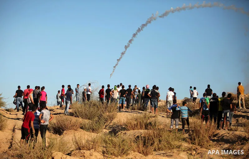 Palestinian protesters take cover during clashes with Israeli security forces near the border between Israel and Central Gaza Strip east of Bureij on Sep. 30, 2016. Photo by Ashraf Amra