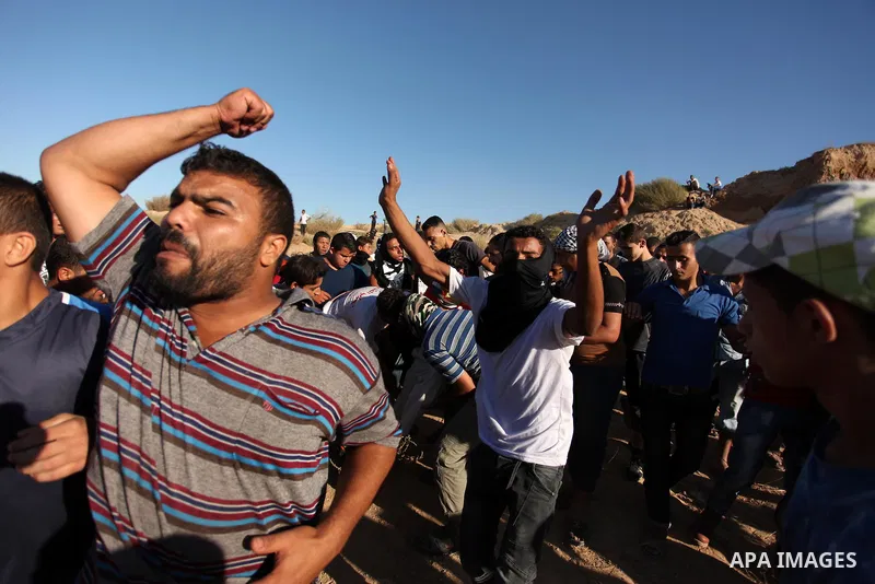 Palestinian protesters carry a wounded comrade during clashes with Israeli security forces near the border between Israel and Central Gaza Strip east of Bureij on Sep. 30, 2016. Photo by Ashraf Amra