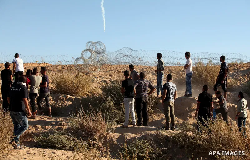 Palestinian protesters take cover during clashes with Israeli security forces near the border between Israel and Central Gaza Strip east of Bureij on Sep. 30, 2016. Photo by Ashraf Amra