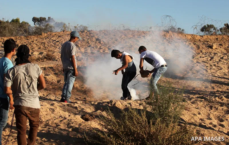 Palestinian protesters take cover during clashes with Israeli security forces near the border between Israel and Central Gaza Strip east of Bureij on Sep. 30, 2016. Photo by Ashraf Amra