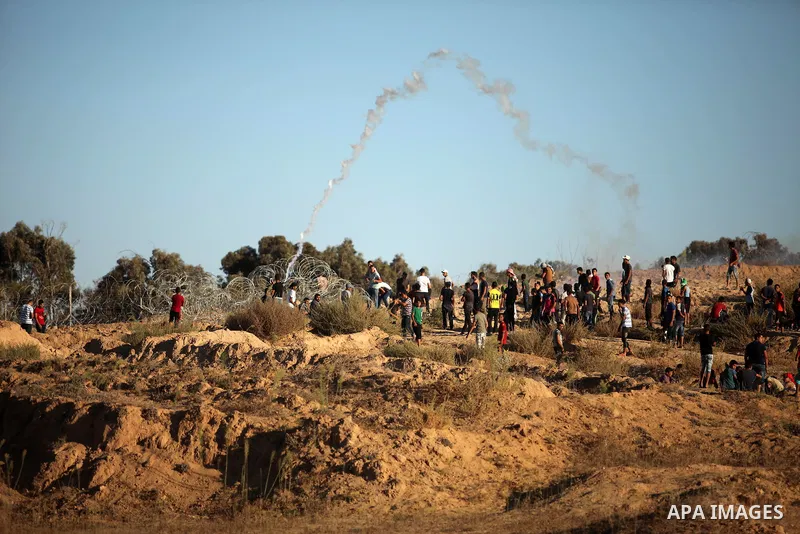 Palestinian protesters take cover during clashes with Israeli security forces near the border between Israel and Central Gaza Strip east of Bureij on Sep. 30, 2016. Photo by Ashraf Amra