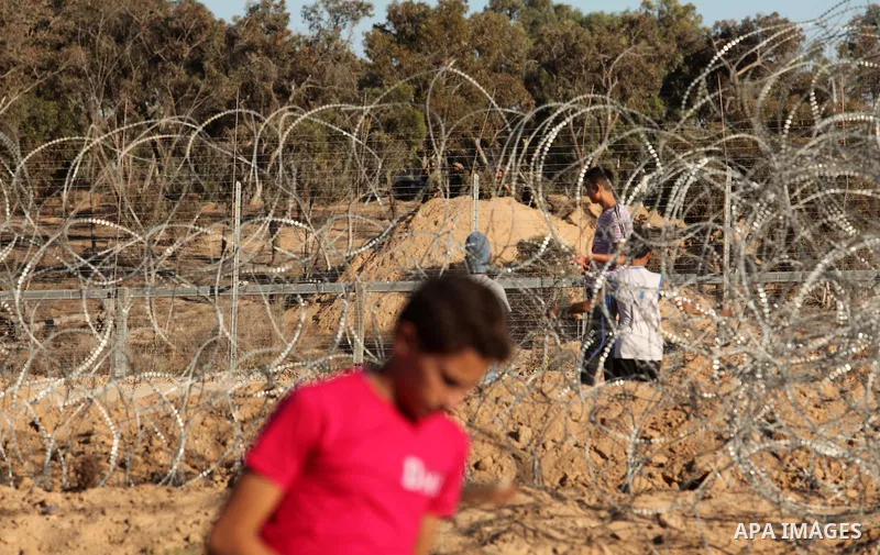 Palestinian protesters take cover during clashes with Israeli security forces near the border between Israel and Central Gaza Strip east of Bureij on Sep. 30, 2016. Photo by Ashraf Amra