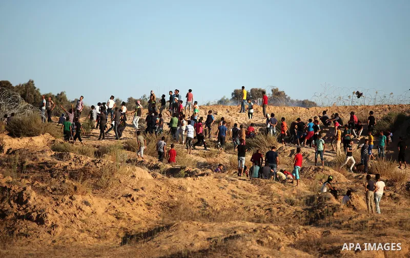 Palestinian protesters take cover during clashes with Israeli security forces near the border between Israel and Central Gaza Strip east of Bureij on Sep. 30, 2016. Photo by Ashraf Amra