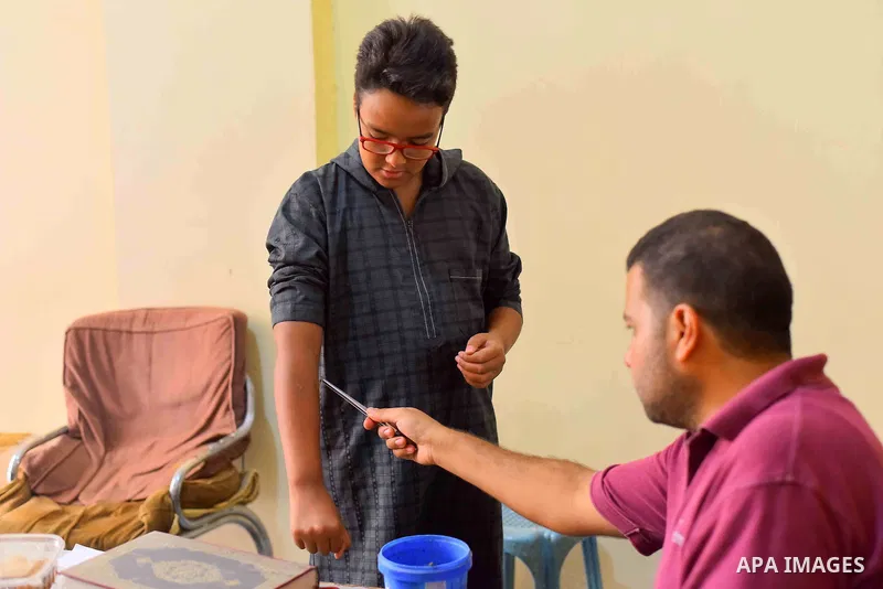 An Egyptian man places a bee on a man suffering from hand problems so it can sting him at a centre in Cairo Out. 01, 2016. Photo by Amr Sayed