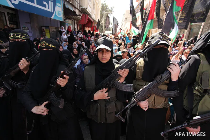 Palestinian women from the Islamic Jihad Movement flash their weapons during a demonstration marking the first anniversary of the so-called Al-Quds uprising in Gaza city, on October 2, 2016. Photo by Ashraf Amra