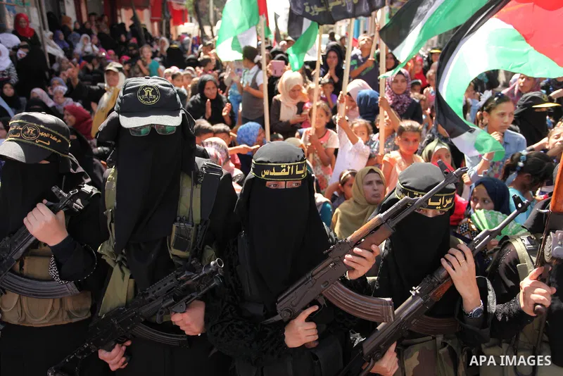 Palestinian women from the Islamic Jihad Movement flash their weapons during a demonstration marking the first anniversary of the so-called Al-Quds uprising in Gaza city, on October 2, 2016. Photo by Ashraf Amra