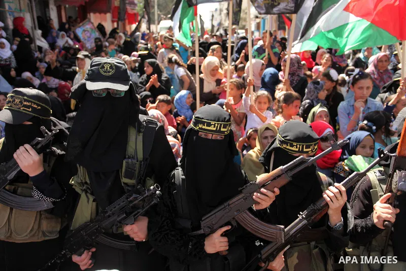 Palestinian women from the Islamic Jihad Movement flash their weapons during a demonstration marking the first anniversary of the so-called Al-Quds uprising in Gaza city, on October 2, 2016. Photo by Ashraf Amra