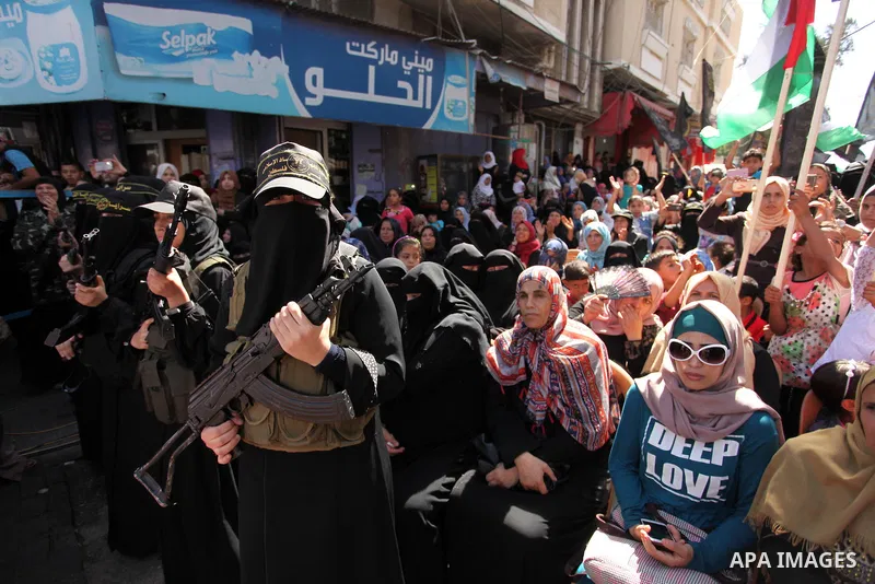 Palestinian women from the Islamic Jihad Movement flash their weapons during a demonstration marking the first anniversary of the so-called Al-Quds uprising in Gaza city, on October 2, 2016. Photo by Ashraf Amra