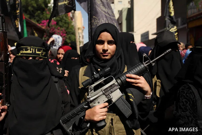 Palestinian women from the Islamic Jihad Movement flash their weapons during a demonstration marking the first anniversary of the so-called Al-Quds uprising in Gaza city, on October 2, 2016. Photo by Ashraf Amra