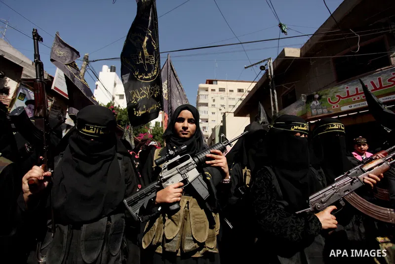 Palestinian women from the Islamic Jihad Movement flash their weapons during a demonstration marking the first anniversary of the so-called Al-Quds uprising in Gaza city, on October 2, 2016. Photo by Ashraf Amra