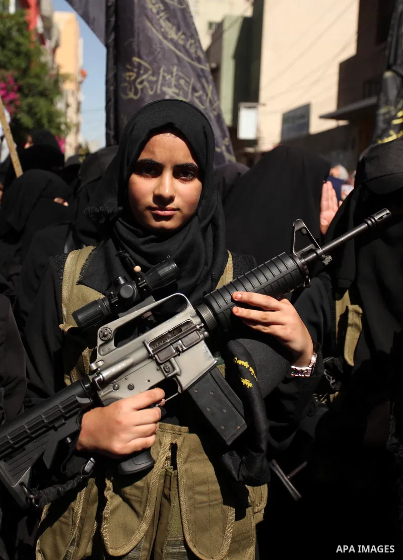 Palestinian women from the Islamic Jihad Movement flash their weapons during a demonstration marking the first anniversary of the so-called Al-Quds uprising in Gaza city, on October 2, 2016. Photo by Ashraf Amra