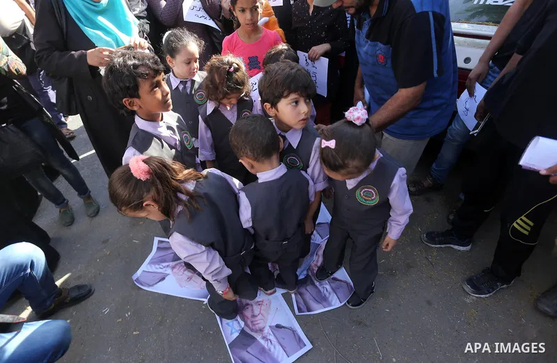 Palestinians burn posters of former Israeli President Shimon Peres during a protest, in front of Red cross office in Gaza city, on Oct. 03, 2016. Photo by Mohammed Asad