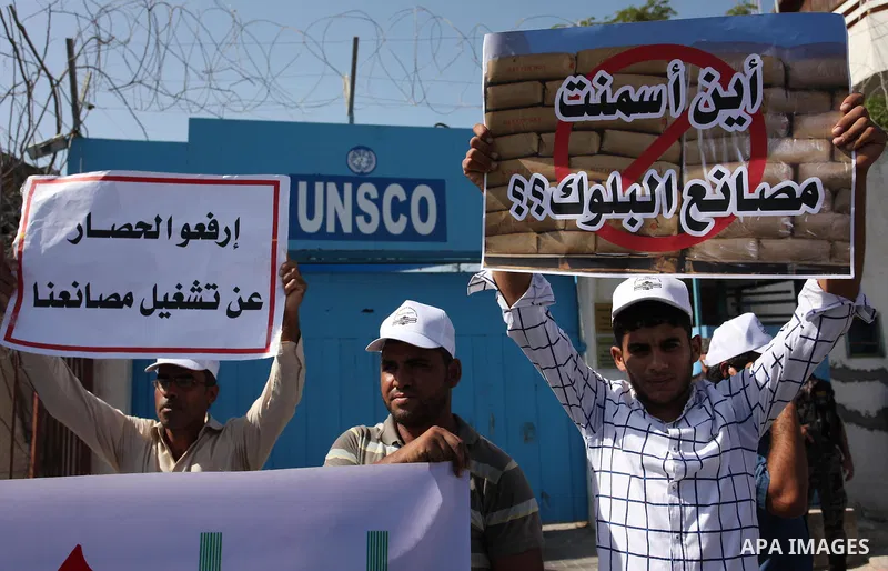 Palestinian owners of factories hold banners during a protest against israeli blockade on operations their factories, in front of the headquarter United Nation "UNSCO", in Gaza city, on October 4, 2016. Photo by Ashraf A...