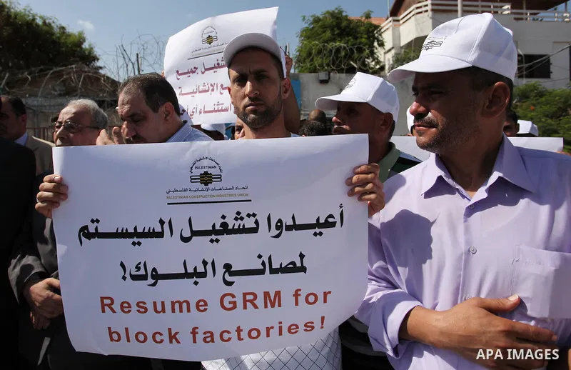 Palestinian owners of factories hold banners during a protest against israeli blockade on operations their factories, in front of the headquarter United Nation "UNSCO", in Gaza city, on October 4, 2016. Photo by Ashraf A...