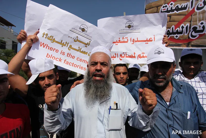 Palestinian owners of factories hold banners during a protest against israeli blockade on operations their factories, in front of the headquarter United Nation "UNSCO", in Gaza city, on October 4, 2016. Photo by Ashraf A...
