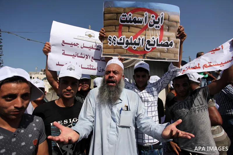 Palestinian owners of factories hold banners during a protest against israeli blockade on operations their factories, in front of the headquarter United Nation "UNSCO", in Gaza city, on October 4, 2016. Photo by Ashraf A...
