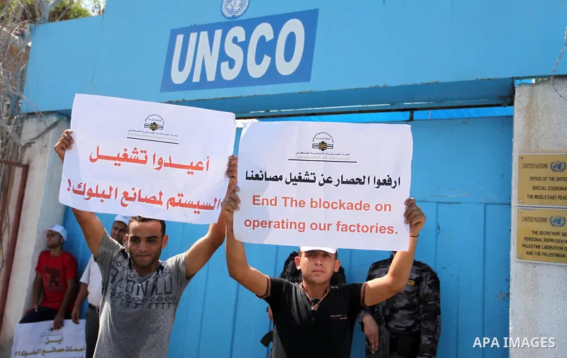 Palestinian owners of factories hold banners during a protest against israeli blockade on operations their factories, in front of the headquarter United Nation "UNSCO", in Gaza city, on October 4, 2016. Photo by Ashraf A...