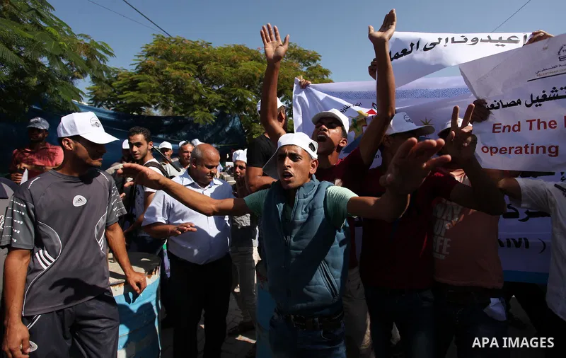 Palestinian owners of factories hold banners during a protest against israeli blockade on operations their factories, in front of the headquarter United Nation "UNSCO", in Gaza city, on October 4, 2016. Photo by Ashraf A...