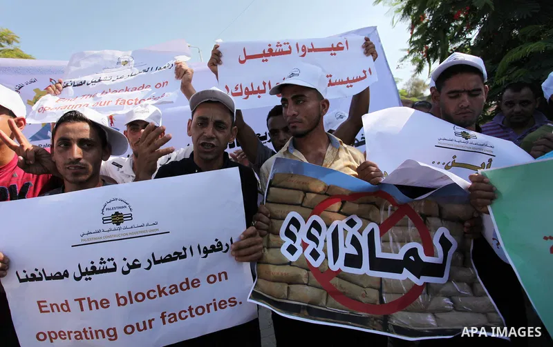Palestinian owners of factories hold banners during a protest against israeli blockade on operations their factories, in front of the headquarter United Nation "UNSCO", in Gaza city, on October 4, 2016. Photo by Ashraf A...
