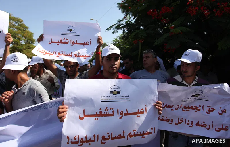Palestinian owners of factories hold banners during a protest against israeli blockade on operations their factories, in front of the headquarter United Nation "UNSCO", in Gaza city, on October 4, 2016. Photo by Ashraf A...