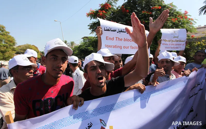 Palestinian owners of factories hold banners during a protest against israeli blockade on operations their factories, in front of the headquarter United Nation "UNSCO", in Gaza city, on October 4, 2016. Photo by Ashraf A...