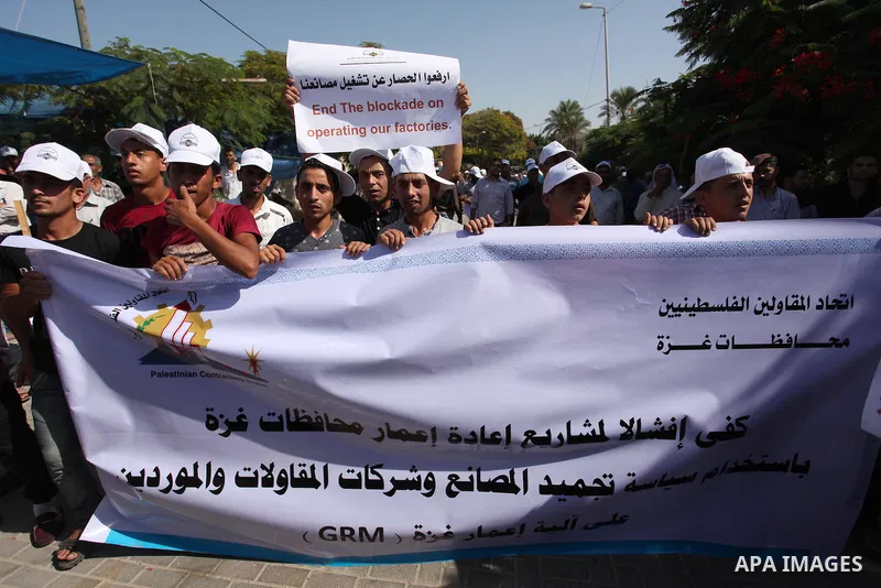 Palestinian owners of factories hold banners during a protest against israeli blockade on operations their factories, in front of the headquarter United Nation "UNSCO", in Gaza city, on October 4, 2016. Photo by Ashraf A...