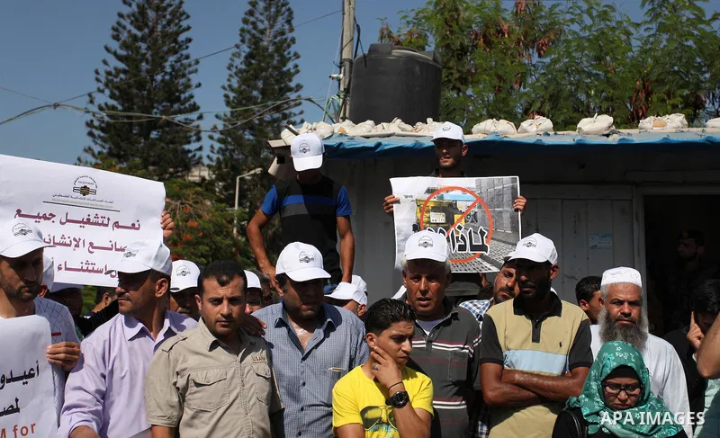 Palestinian owners of factories hold banners during a protest against israeli blockade on operations their factories, in front of the headquarter United Nation "UNSCO", in Gaza city, on October 4, 2016. Photo by Ashraf A...