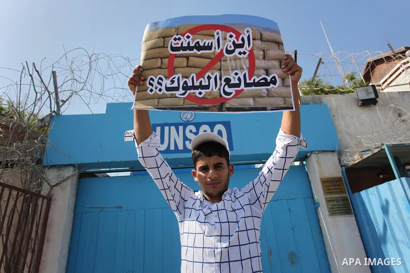 Palestinian owners of factories hold banners during a protest against israeli blockade on operations their factories, in front of the headquarter United Nation "UNSCO", in Gaza city, on October 4, 2016. Photo by Ashraf A...