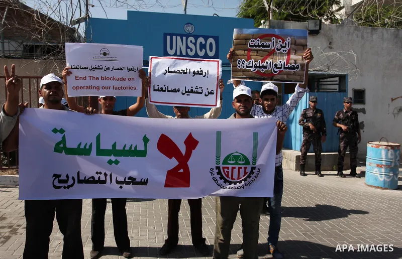 Palestinian owners of factories hold banners during a protest against israeli blockade on operations their factories, in front of the headquarter United Nation "UNSCO", in Gaza city, on October 4, 2016. Photo by Ashraf A...