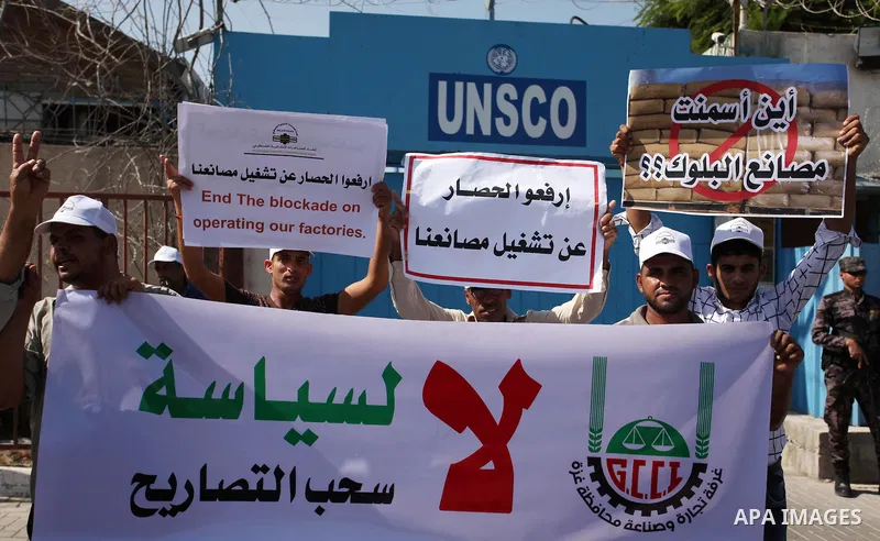 Palestinian owners of factories hold banners during a protest against israeli blockade on operations their factories, in front of the headquarter United Nation "UNSCO", in Gaza city, on October 4, 2016. Photo by Ashraf A...