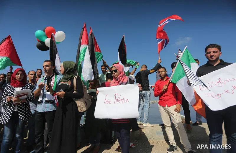 Palestinian youths hold banners during a rally to show solidarity with ship called “Zaytouna” set to arrive in Gaza, at the Seaport of Gaza City October 5, 2016. Photo by Mohammed Asad
