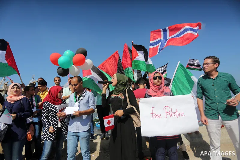 Palestinian youths hold banners during a rally to show solidarity with ship called “Zaytouna” set to arrive in Gaza, at the Seaport of Gaza City October 5, 2016. Photo by Mohammed Asad
